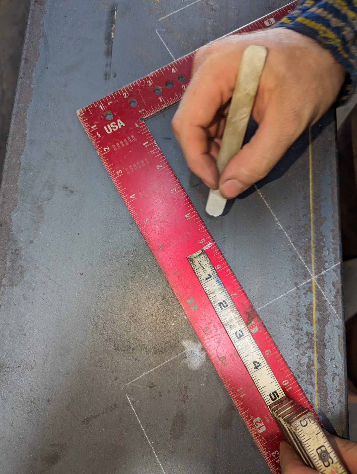 Soapstone and framing square marking layout on steel