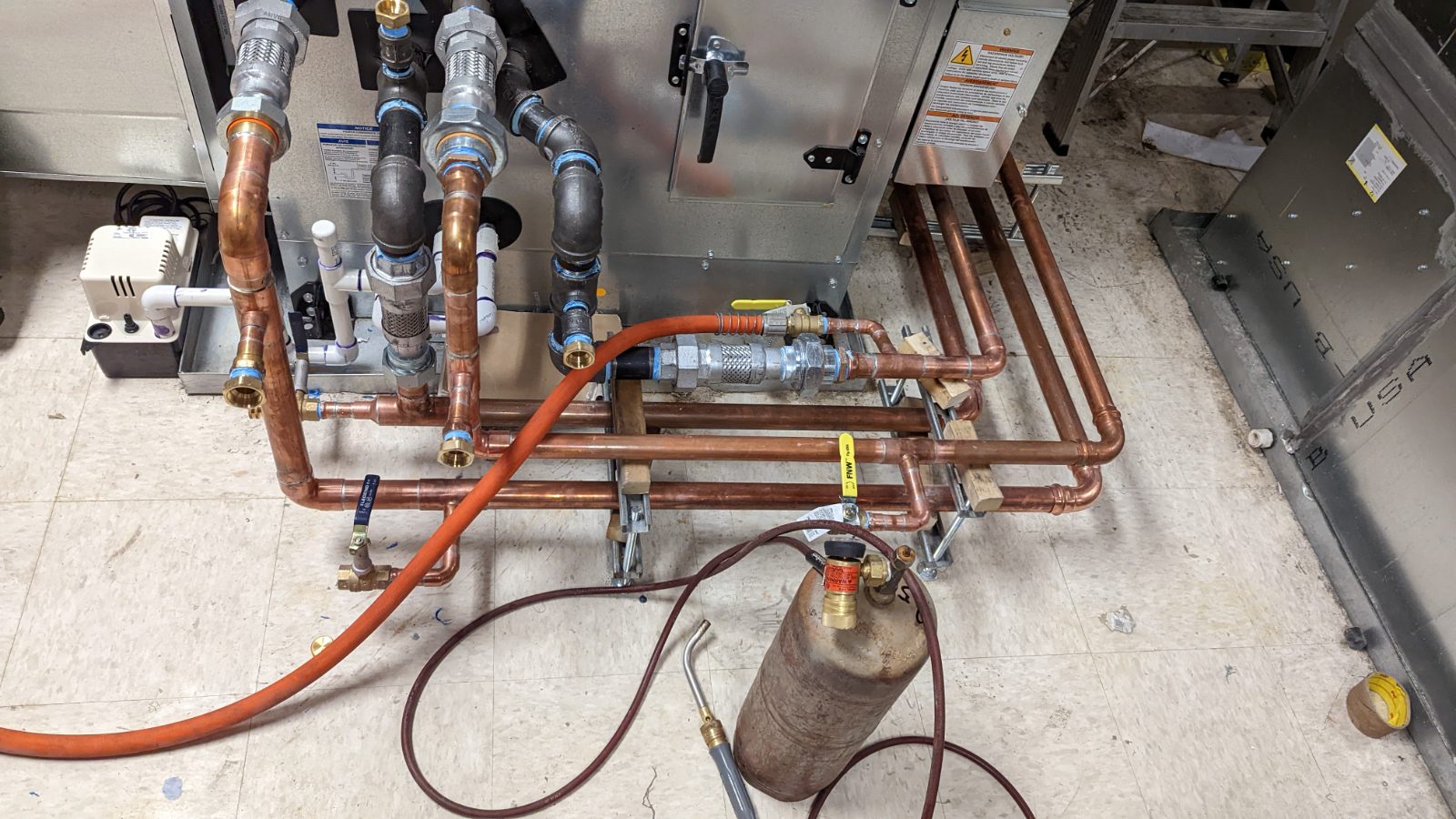 Clean copper manifold with brass unions at a mechanical unit