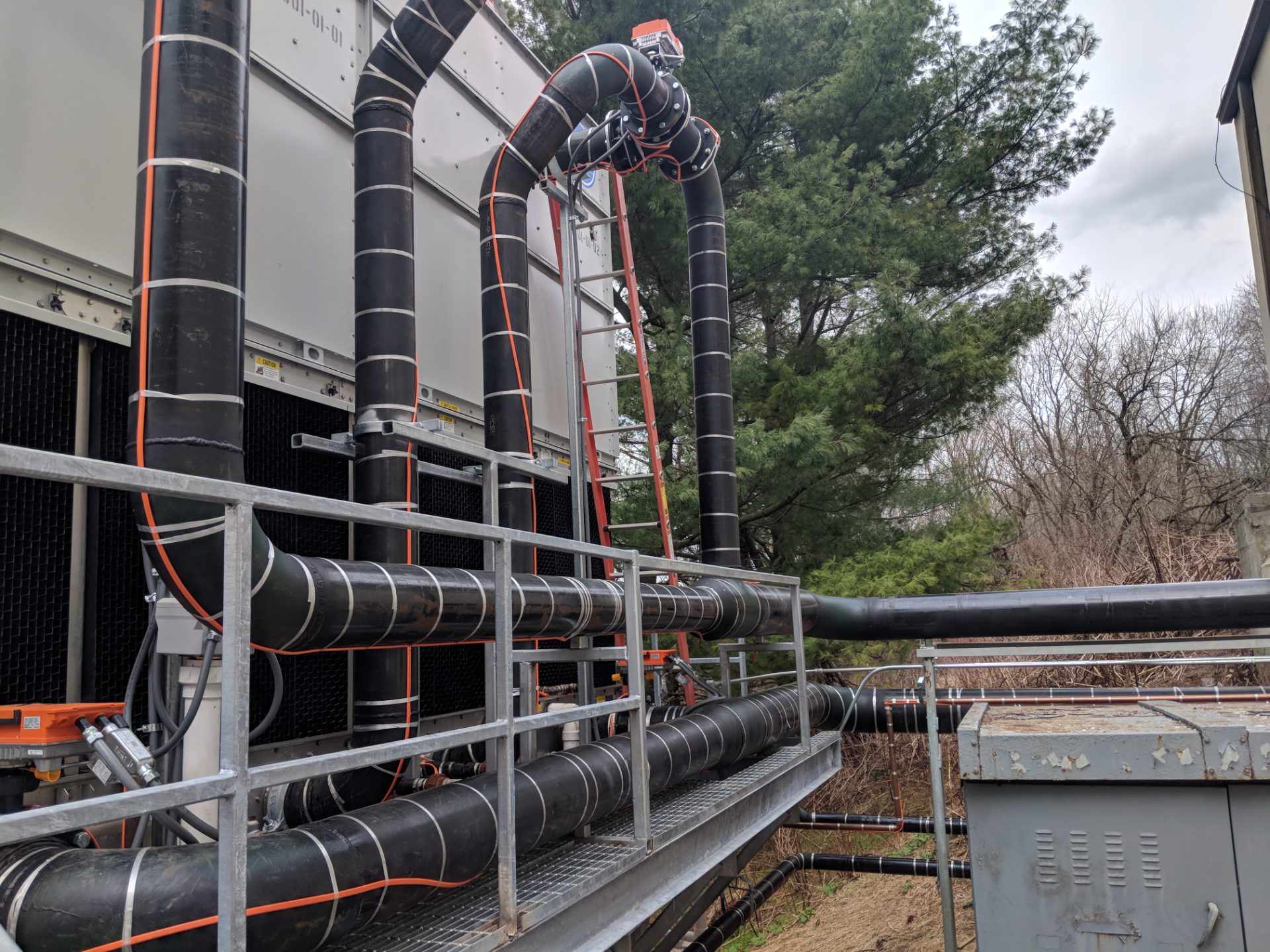 Insulated process piping and rolling offsets running to a cooling tower — Bel Air Mechanical